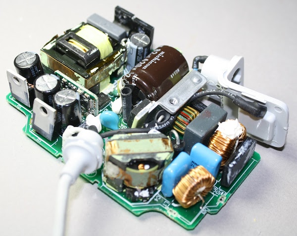 An Apple power adapter, with the cover removed